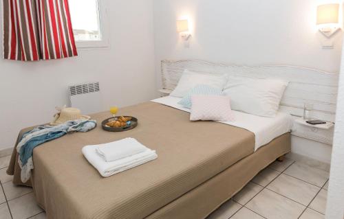 a bedroom with a bed with a tray of food on it at Résidence Odalys Les Hauts de Salavas in Salavas