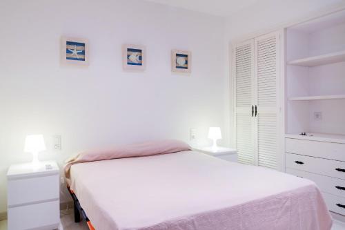 um quarto branco com uma cama e 2 candeeiros em Ancora em Tamariu