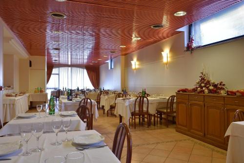 a dining room with tables and chairs with white tablecloths at Dropiluc in Druento