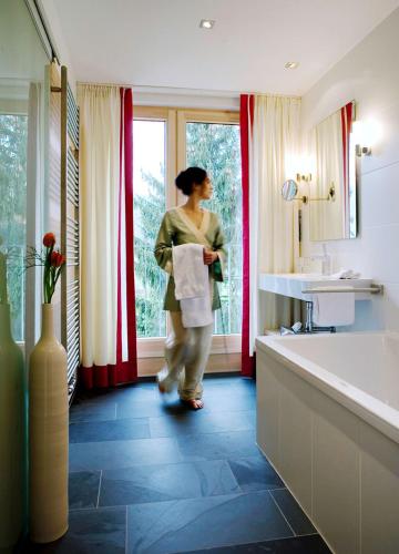a woman standing in a bathroom looking out the window at Schlegelhof in Kirchzarten