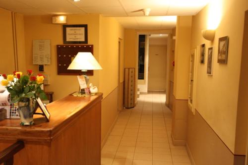 a hallway of a hospital with a reception desk and a hallway sidx sidx at Logis Hotel L'ange Couronne in Belleville-sur-Saône