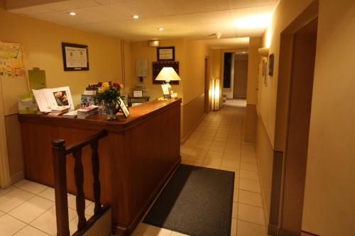 a hotel lobby with a reception desk and a hallway at Logis Hotel L'ange Couronne in Belleville-sur-Saône