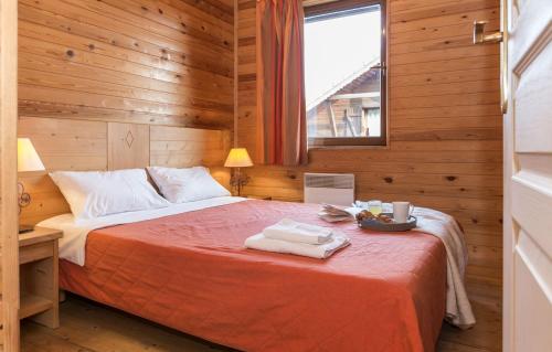 a bedroom with a bed in a wooden room at Résidence Odalys Les Chalets d'Evian in Évian-les-Bains