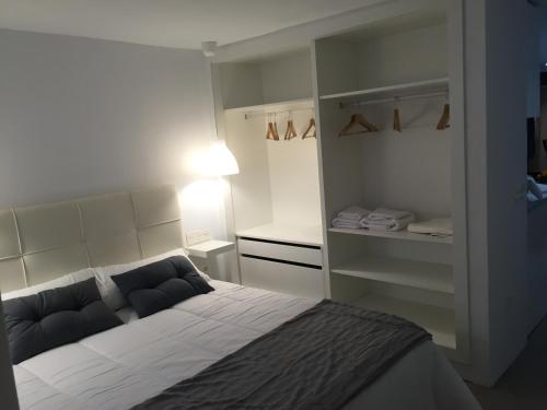 um pequeno quarto com uma cama e um closet em Apartamento Playa Encantador em Puerto del Carmen