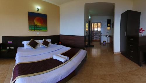 a large bedroom with two beds with white sheets at Kasang Regency Hill Resort in Lansdowne