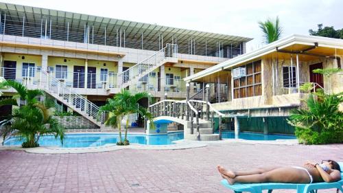 a woman laying on a chair in front of a hotel at GingGing Hotel And Resort in Oslob