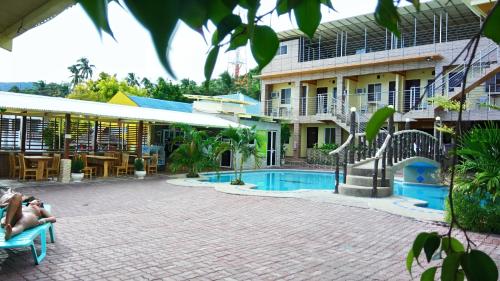 a resort with a swimming pool in front of a building at GingGing Hotel And Resort in Oslob