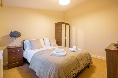1 dormitorio con 1 cama con toallas en Skyline Serviced Apartments - Colestrete en Stevenage