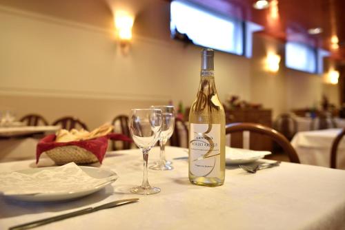 a bottle of wine sitting on a table with a glass at Dropiluc in Druento
