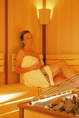 a woman sitting on a bed in a room at Alpenresidenz Trisanna in Ischgl