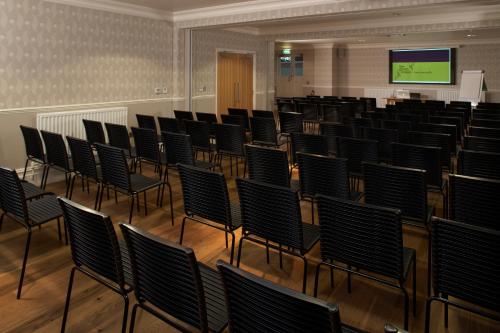 an empty room with chairs and a screen at The Green House in Bournemouth