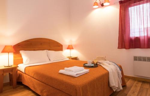 um quarto com uma cama com duas toalhas em Résidence Odalys Les Sources de Manon em Vallon-Pont-dʼArc