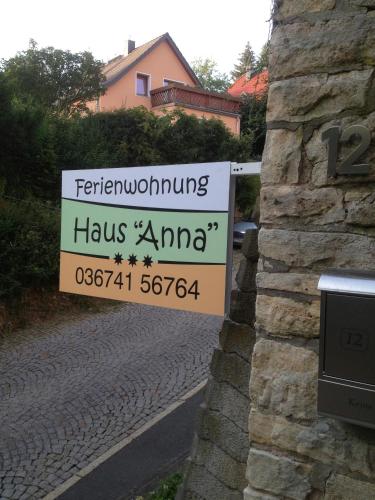 a sign on the side of a building with a house at Ferienwohnung Haus "Anna" in Bad Blankenburg