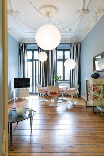 a living room with two chandeliers and a table at Brilliant Apartments in Berlin