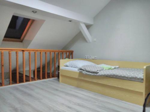 a small bedroom with a bed and a staircase at Apartman Merkur in Sombor