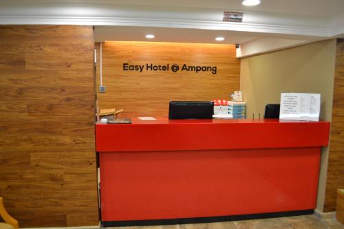 an office with a red desk and a sign that reads easy hotel ganger at Eazy Hotel at Ampang in Batu Empat