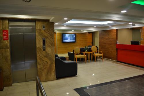a lobby with a waiting room with a table and chairs at Eazy Hotel at Ampang in Batu Empat