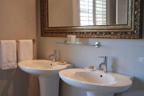 a bathroom with two sinks and a mirror and towels at St Leonards Lodge in Dunedin