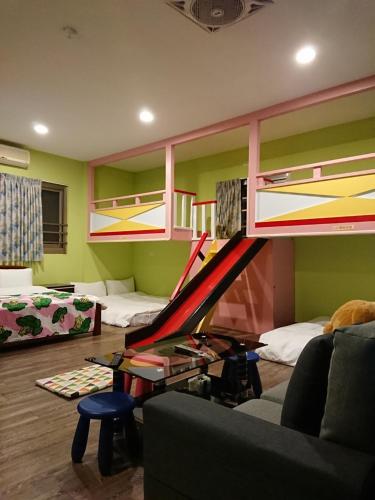 - un salon avec une mezzanine dotée d'un toboggan dans l'établissement Sun Moon Flower Homestay, à Yuchi