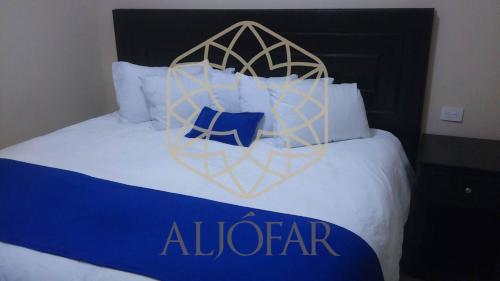Una cama grande con un cartel de alvarado. en Hotel Aljófar, en Montemorelos