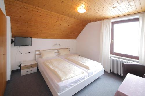 ガッゲナウにあるHotel Platzhirschのベッドルーム(白いベッド1台、窓付)