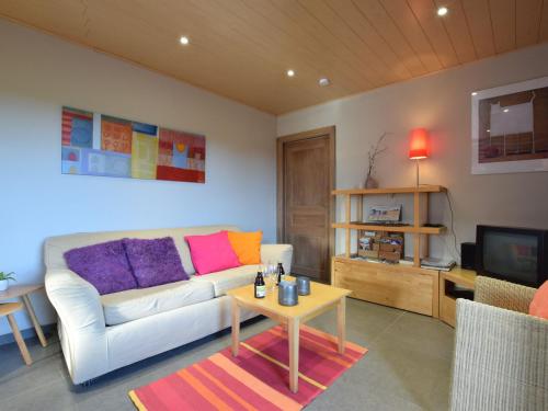 uma sala de estar com um sofá branco e uma mesa em Peaceful Cottage in Ardennes with Private Terrace em Bastogne