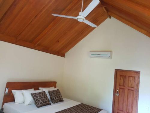 a bedroom with a ceiling fan and a bed at Inn On The Bay in Pasikuda