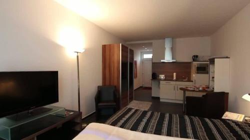 a hotel room with a bed and a flat screen tv at Campus Boardinghouse in Aachen