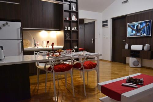 kuchnia ze stołem z krzesłami i lodówką w obiekcie Apartment Fine Living 122 w mieście Vršac