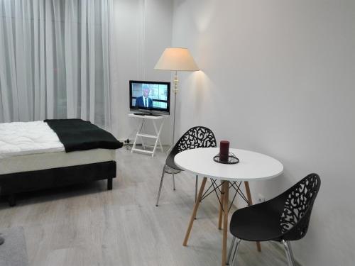 1 dormitorio con 1 cama, mesa y sillas en VaBank Apartamenty w centrum, en Zielona Góra