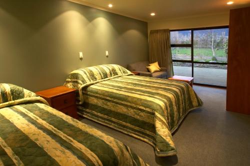 um quarto de hotel com duas camas e uma janela em Donegal House em Kaikoura