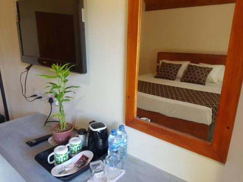 a mirror on a table in a room with a bed at Inn On The Bay in Pasikuda