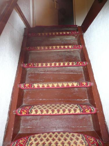 a set of four wooden stairs with colorful carpet at Adventure House (Abenteuerferienhaus) in Rechenberg-Bienenmühle