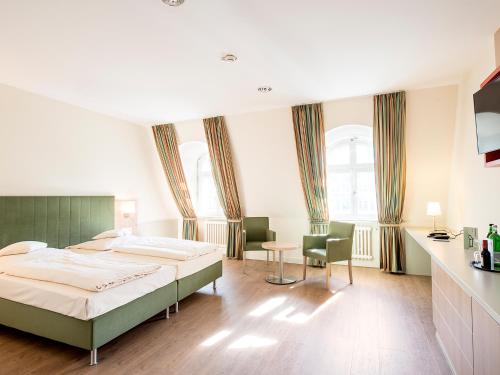 - une chambre avec un lit, une table et des chaises dans l'établissement Hotel Axel Springer, à Berlin