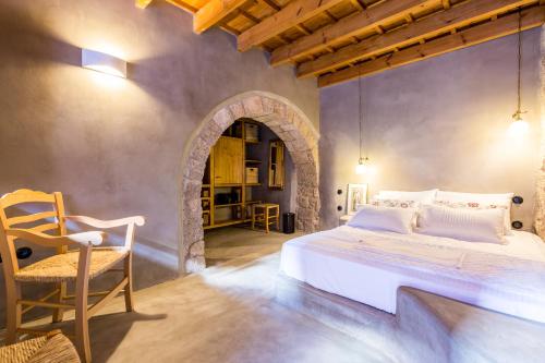 a bedroom with a large white bed and a chair at Rodi in Rhodes Town