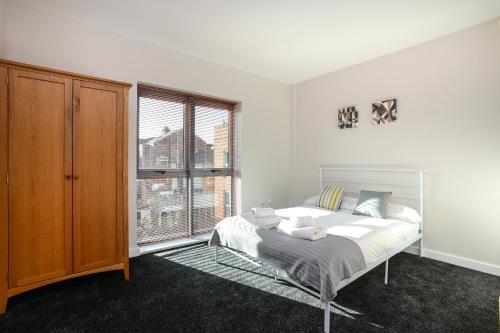 a bedroom with a bed and a large window at Portland Square - 2 Bedroom Modern City Apartment in Nottingham