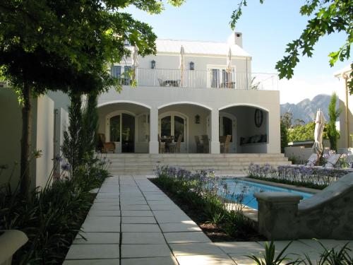 a villa with a swimming pool and a house at Maison d'Ail Guest House in Franschhoek