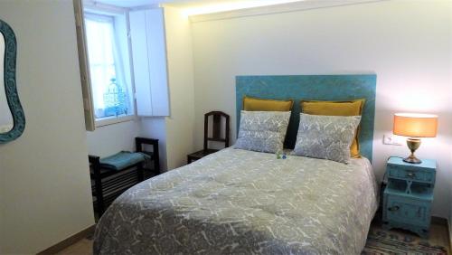 リスボンにあるCasinhas da Ajuda nº25のベッドルーム1室(大型ベッド1台、青いヘッドボード付)