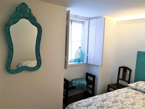 a bedroom with a mirror and a bed and a window at Casinhas da Ajuda nº25 in Lisbon