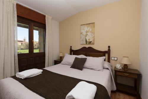 a bedroom with a bed with white sheets and a window at Hotel Rural Santa Inés in Vinuesa