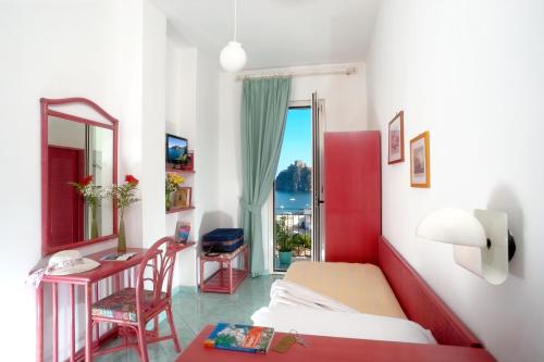 1 dormitorio con cama, escritorio y ventana en Hotel Ulisse en Ischia