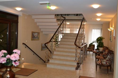 a spiral staircase in a living room with flowers at Gilija in Šilutė