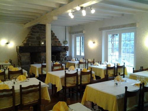 a restaurant with tables and chairs with yellow table cloth at La Cremaillere in Miremont