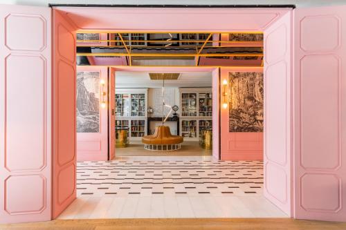 a hallway with pink doors and a room with a chair at Room Mate Emir, Istanbul in Istanbul