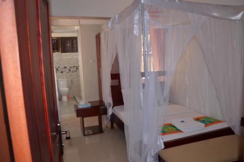 a bedroom with a bed with a plastic canopy at Sheevy"s Bed N Breakfast in Fort Portal