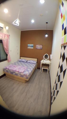 a bedroom with a bed and a table in it at 龍園旅館Long Yuan Hotel in Budai