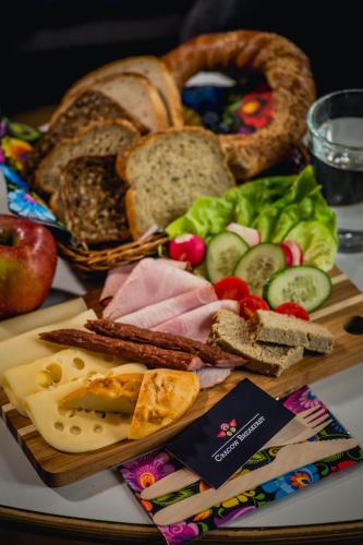 a plate of food with bread and meats and vegetables at Aparthotel BC 29 Residence in Kraków