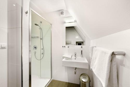 a white bathroom with a sink and a shower at CK Pension in Český Krumlov