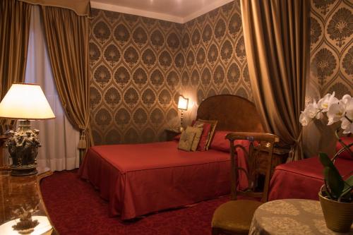 a bedroom with two beds and a table with a lamp at Hotel Metropole Venezia in Venice