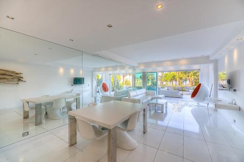 - un salon avec des tables, des chaises et un canapé dans l'établissement Appartement l'Age d'Or, à Cannes